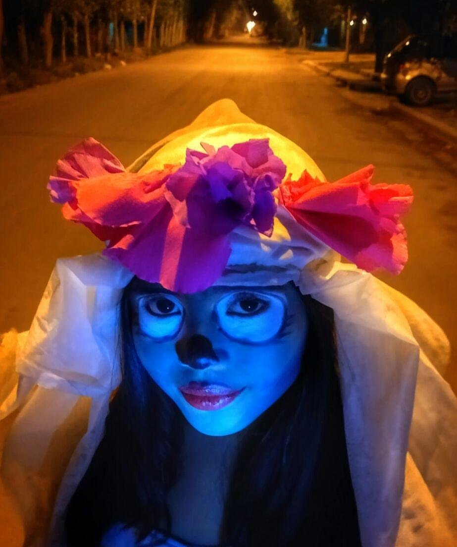 Niña con maquillaje de calavera iluminada de azul